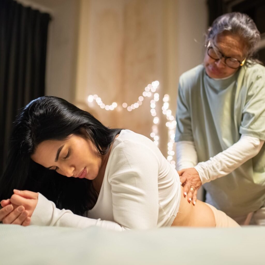 A doula masssaging a woman having a homebirth