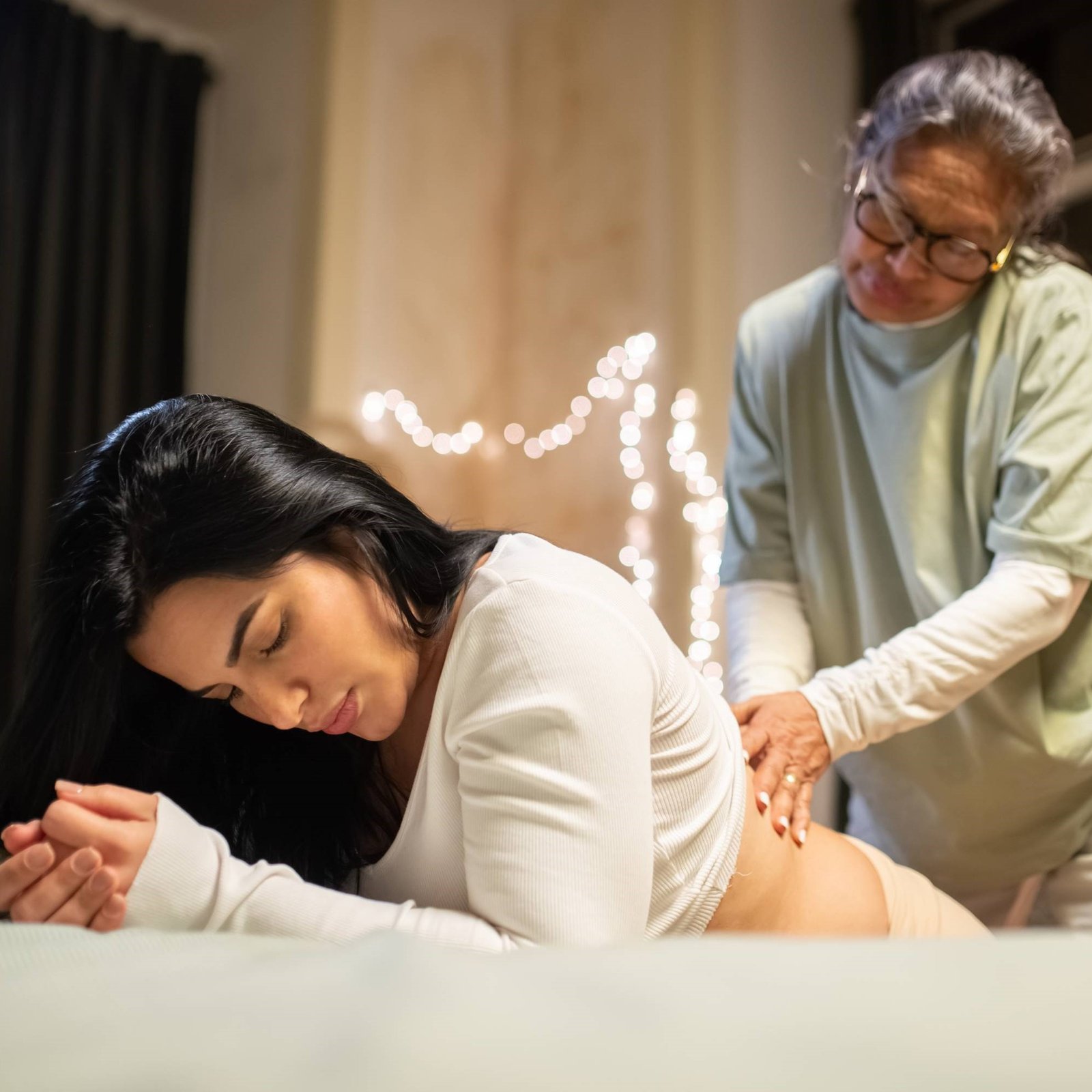 A doula masssaging a woman having a homebirth